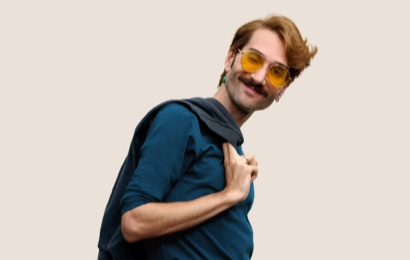 Portrait of a smiling Apple Retail team member with short, dark blond hair and eyeglasses.