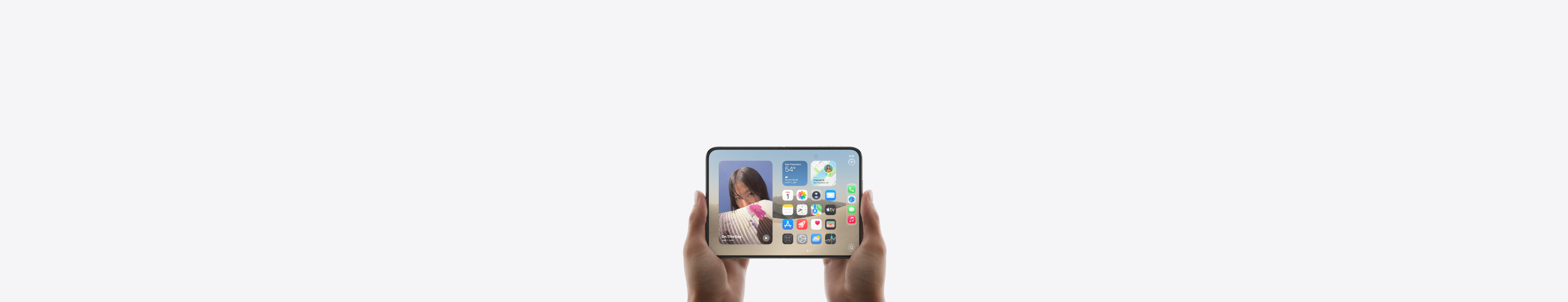 iPhone Duo, held by two hands in landscape orientation, unfolded, interior display features Home Screen.