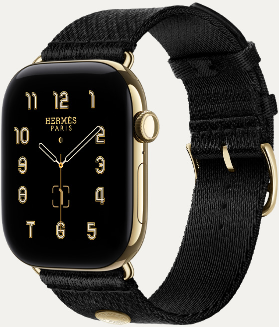 燦金色鈦金屬錶殼 Apple Watch Hermès Series 12，採用 Clou de Selle 指針錶面 (小時、分鐘與秒針，以及多項複雜功能，包括月相、日期)，右側外觀上有數位錶冠、側邊按鈕，搭配 Noir 黑色 Satin Clou de Selle 錶帶，光滑的黑色緞面織帶搭配燦金色五金飾件，與錶殼完美相襯