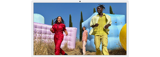 Three people in bright outfits, surrounded by colorful inflatable shapes